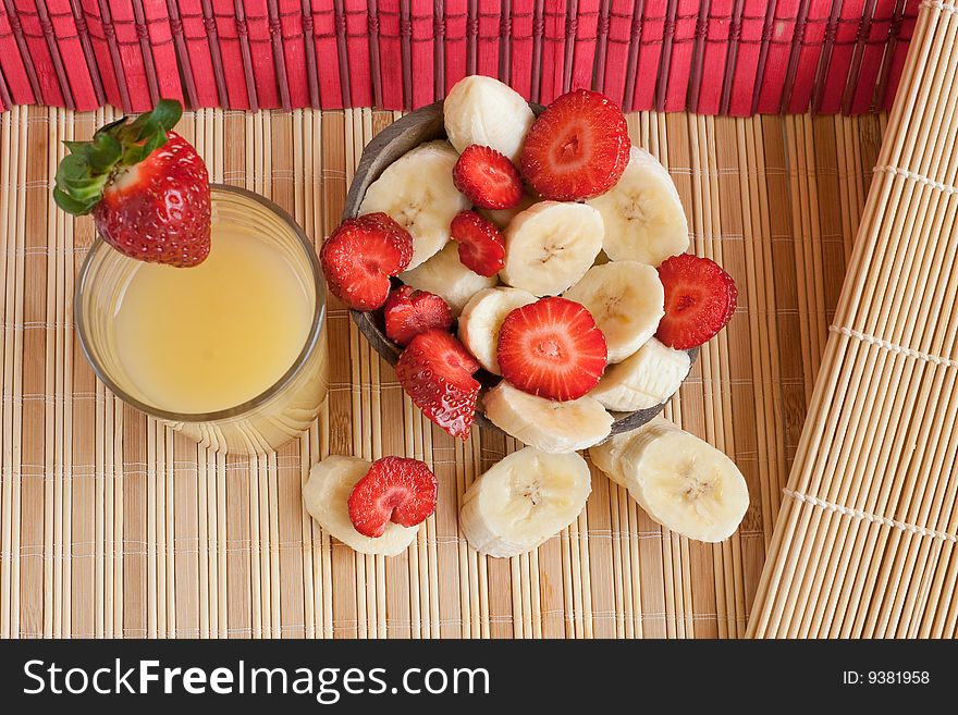 Tropic lunch: cut bananas and strawberries served in a coconut and a glass of juice (2). Tropic lunch: cut bananas and strawberries served in a coconut and a glass of juice (2)