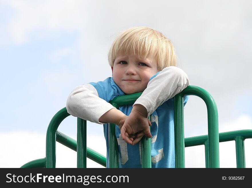Small boy climbed to the top of slide and watching around. Small boy climbed to the top of slide and watching around