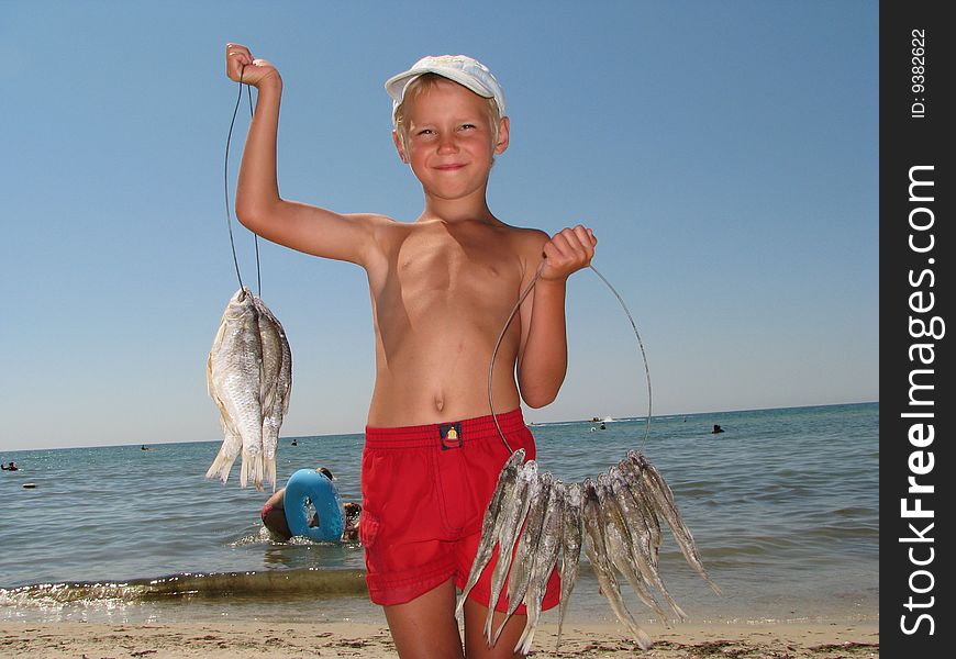 The young guy sells the dried up fish on seacoast,. The young guy sells the dried up fish on seacoast,