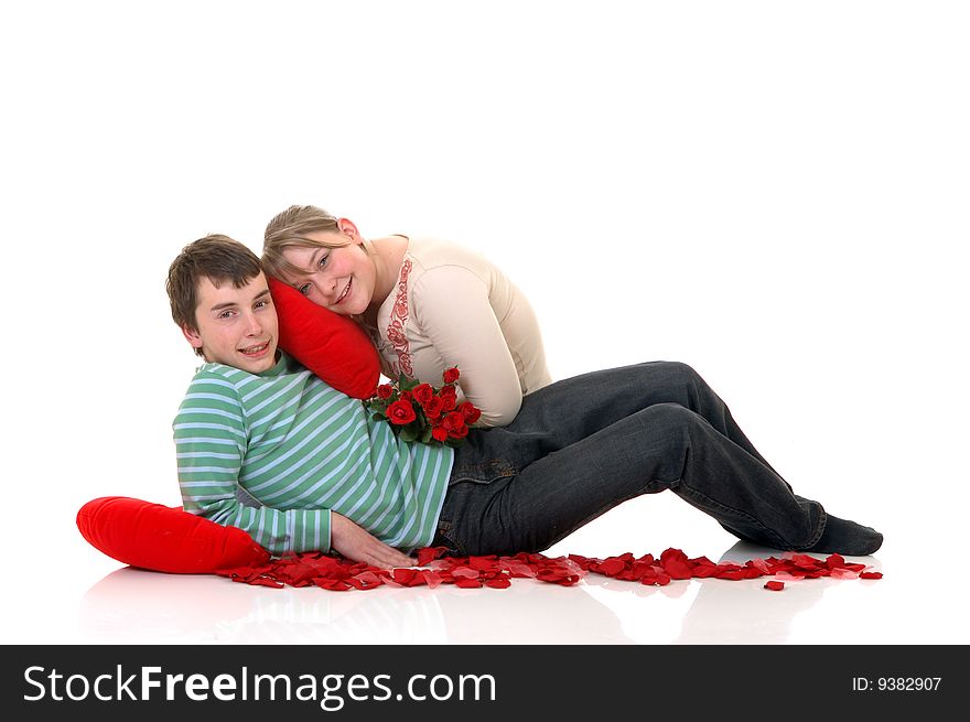 Two casual dressed teenagers, teenage man and woman in love, surrounded with rose petals. studio shot. Two casual dressed teenagers, teenage man and woman in love, surrounded with rose petals. studio shot.
