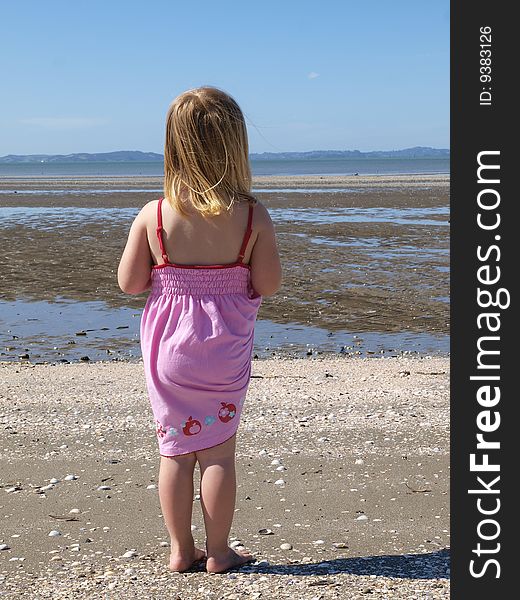 A little girl staring out to sea. A little girl staring out to sea