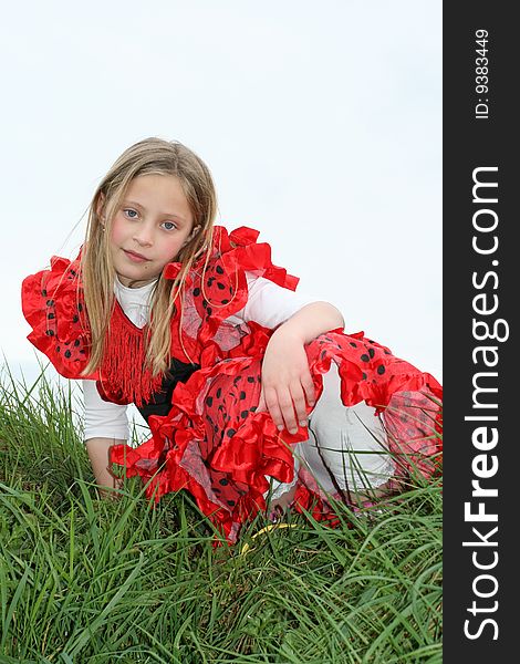 Small girl in red dress posing on the grass. Small girl in red dress posing on the grass