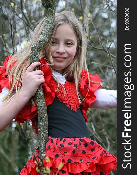 Girl in the red dress climbed up the tree and she looks happy. Girl in the red dress climbed up the tree and she looks happy
