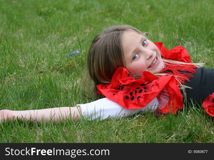 Small girl in red dress posing on the grass. Small girl in red dress posing on the grass