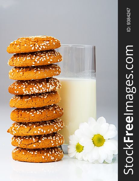 Biscuits in stack and milk glass, on grey. Biscuits in stack and milk glass, on grey