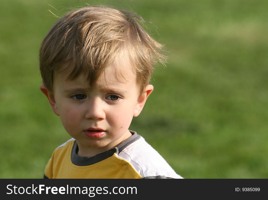 Small boy on the pitch, concentration visible on the face. Small boy on the pitch, concentration visible on the face