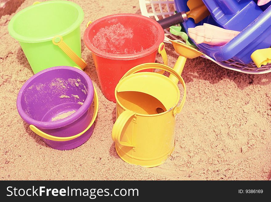 A collection of childrens buckets on a sandy beach. A collection of childrens buckets on a sandy beach