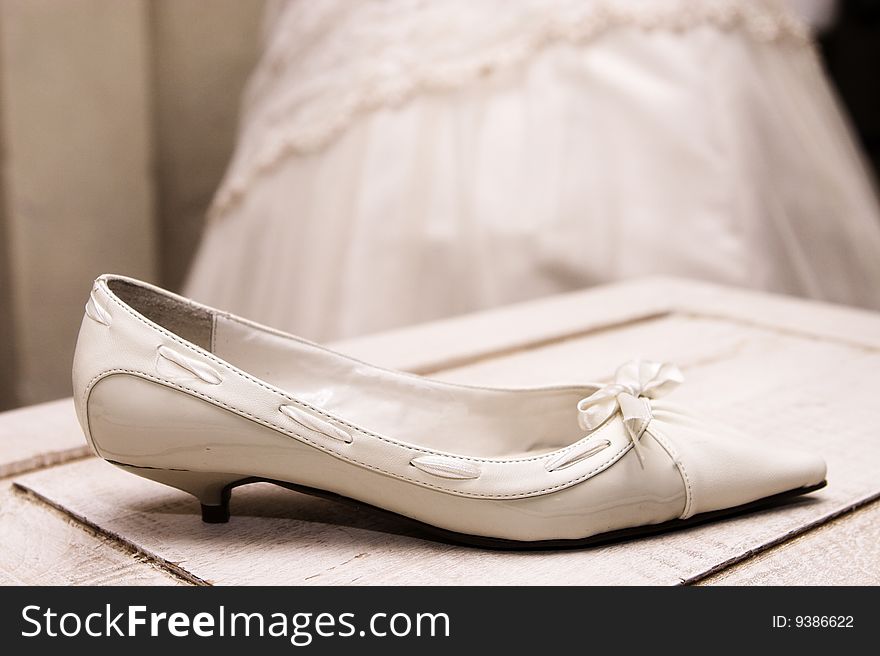 Light Colored wedding shoe on a wooden table