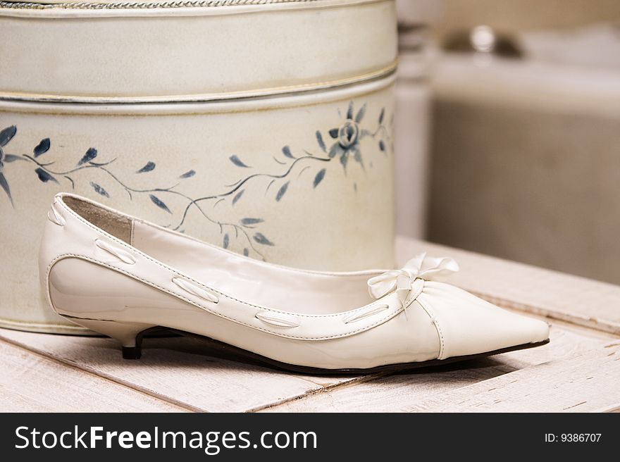 Light Colored wedding shoe against a hat box