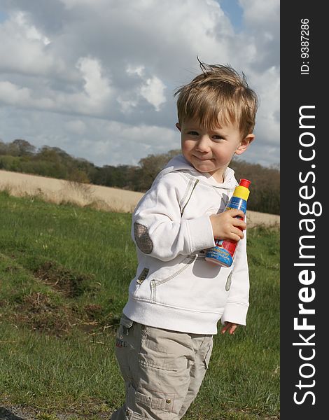 Boy with a bottle of juice watching nature. Boy with a bottle of juice watching nature