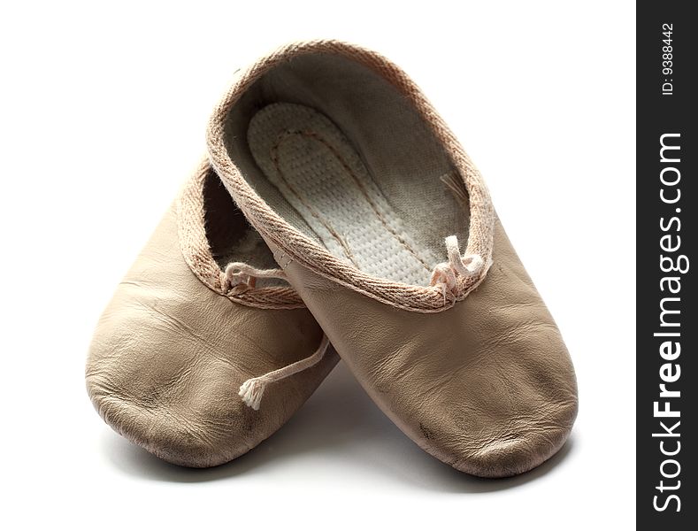 A pair of used child's ballet shoes isolated on a white background