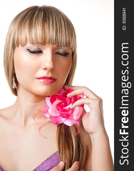 Blonde girl in pink dress and makeup with rose in her hair on white background