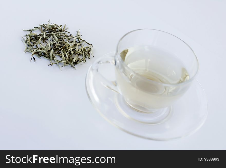 White tea and tea leaves on the table in transparent cup. White tea and tea leaves on the table in transparent cup