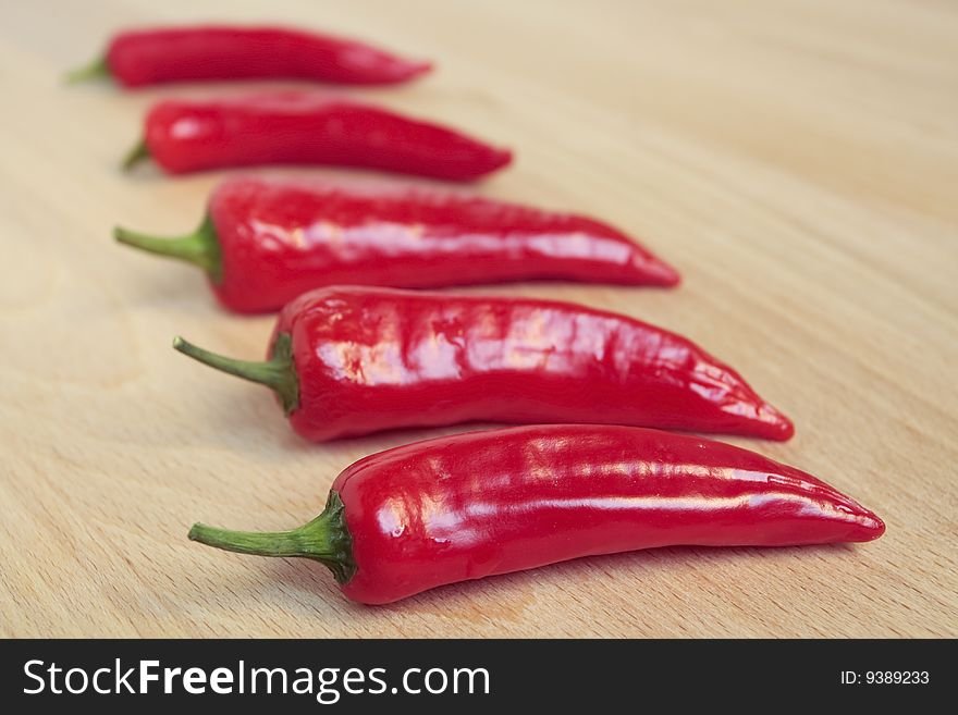 Red chili peppers on wooden chopping board