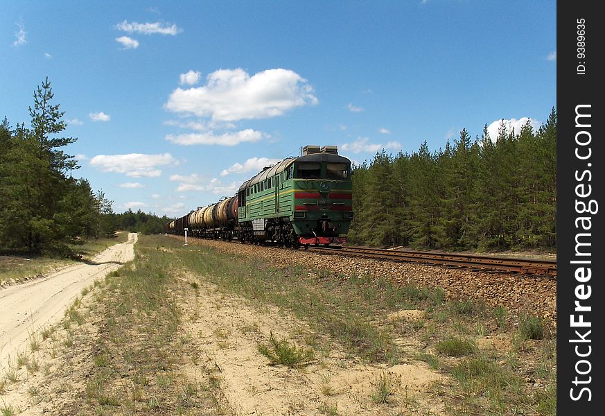 Cargo train diesel locomotive in the pine forest. 
Ukraine. May 2009. Cargo train diesel locomotive in the pine forest. 
Ukraine. May 2009.