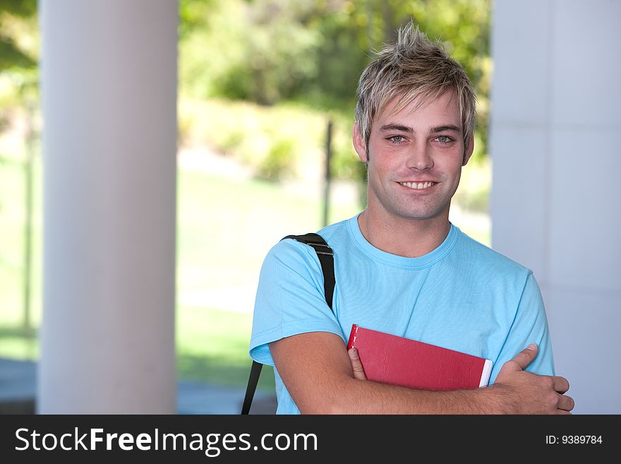 Portrait of male student holding a book.