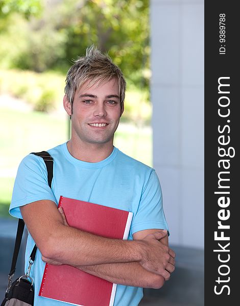 Portrait of male student holding a book.
