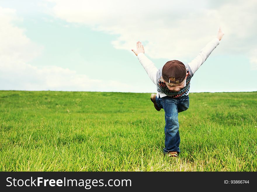 A kid running on green grass. A kid running on green grass.