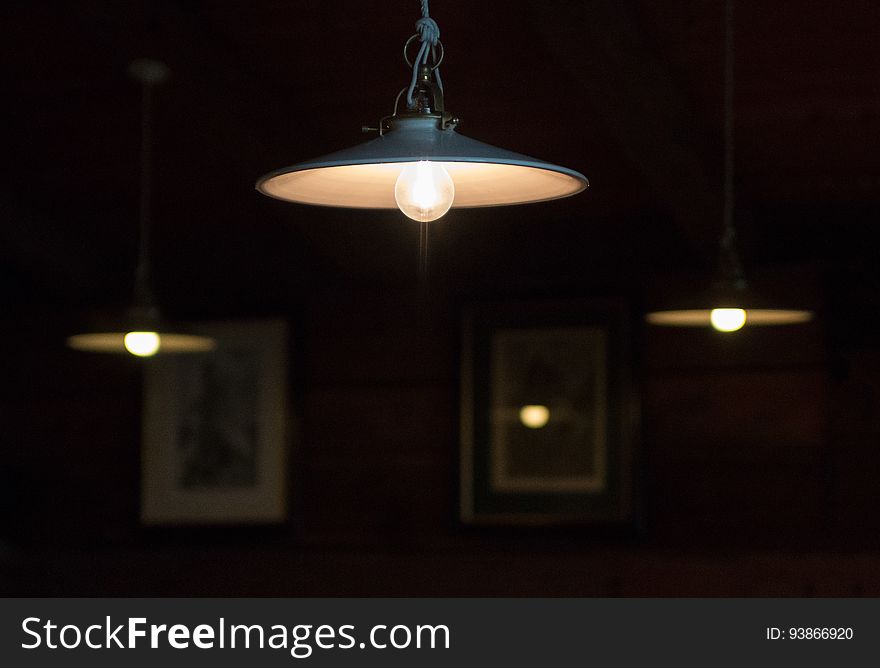 Hanging light fixtures, glowing softly in the darkness.
