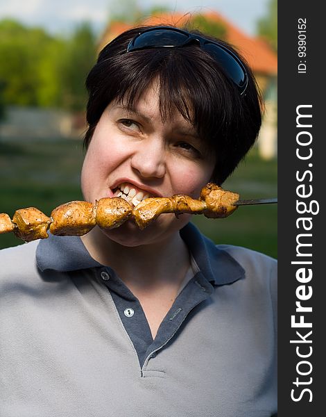 The woman eat of chicken grill. The woman eat of chicken grill
