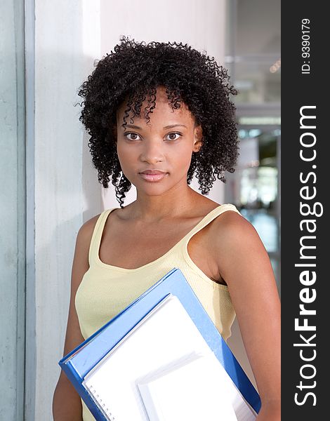 Portrait of female student holding files.