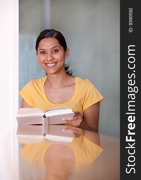 Portrait of female student reading a book.