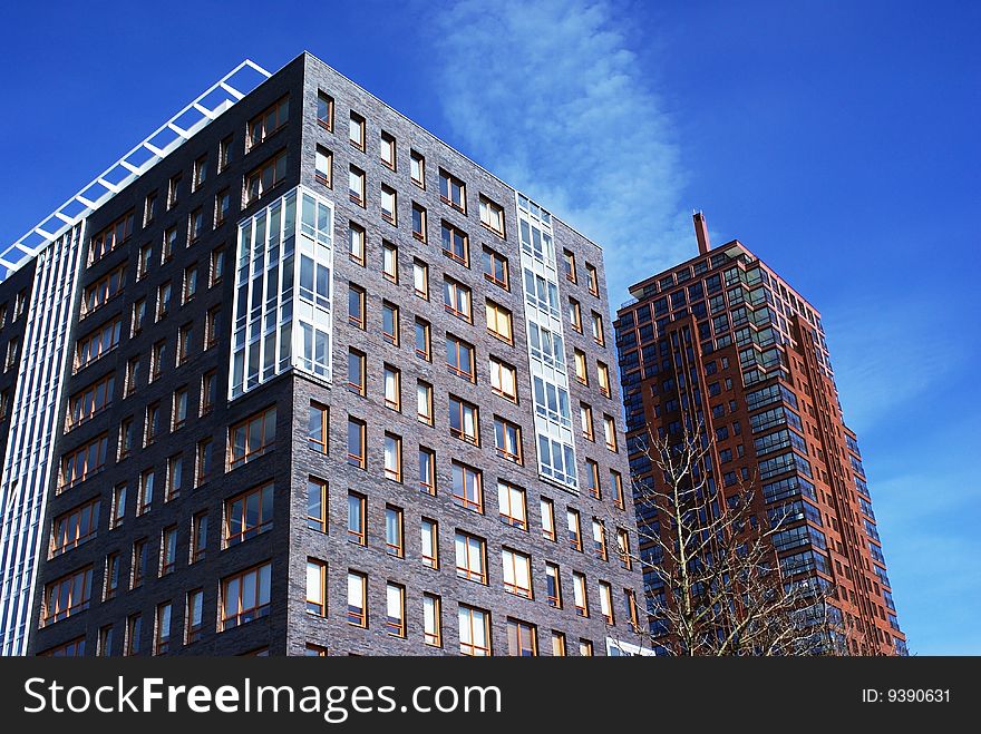 Two large buildings against a blue sky. Two large buildings against a blue sky.