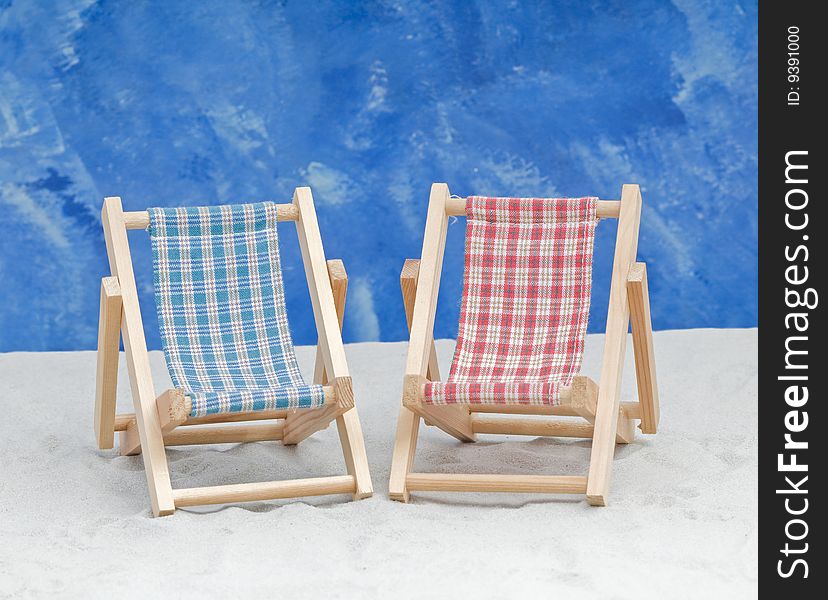 Blue and red  deckchairs on a  beach by the sea