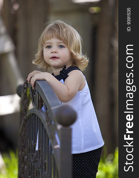 Little girl standing on bridge in white top. Little girl standing on bridge in white top