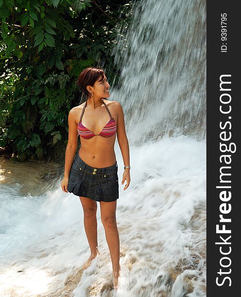 The girl standing close to the waterfall in Ocho Rios town garden, Jamaica. The girl standing close to the waterfall in Ocho Rios town garden, Jamaica.