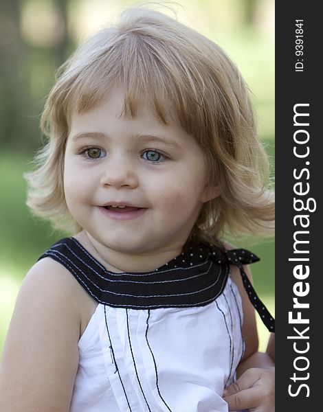 Little girl with blue and brown eyes outside