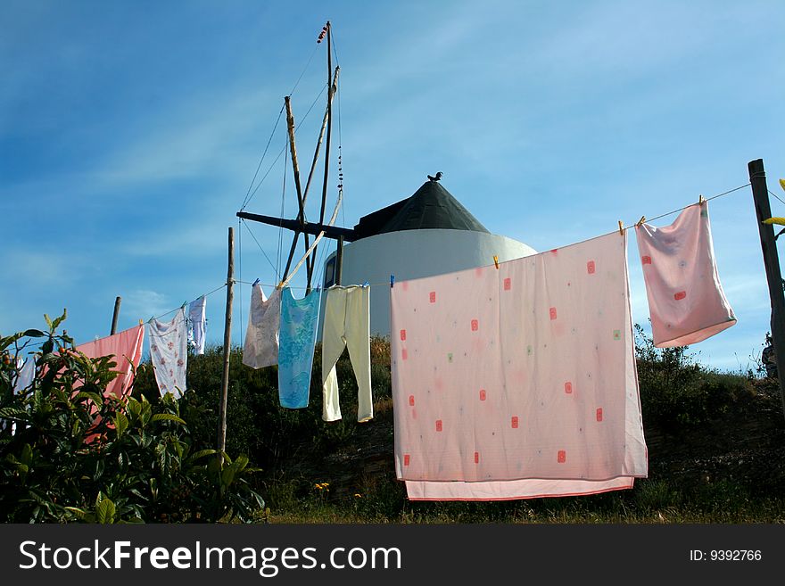 Typical portuguese scene: functional old windmill and clothes