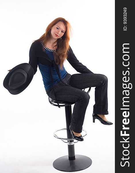 Young girl with  black hat sitting on chair on white background. Young girl with  black hat sitting on chair on white background