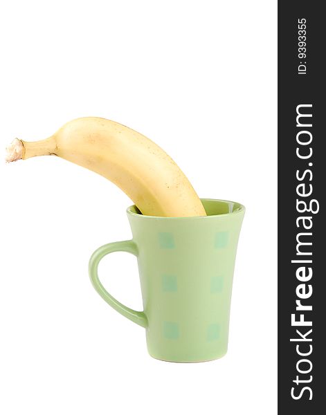 Yellow banana in a cup as a symbol of the squeezed out fresh juice.