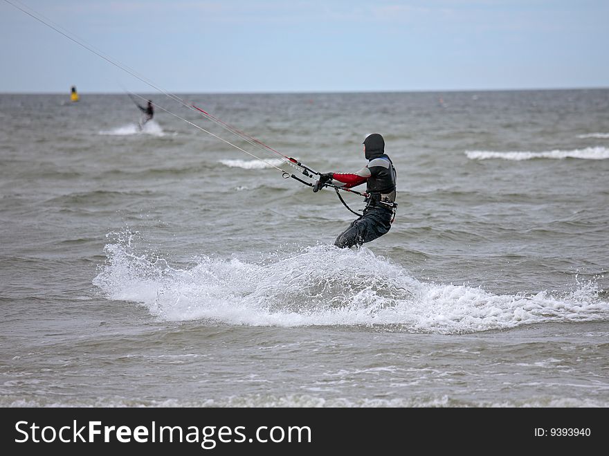 Surfing-man under wing in the cold Baltic sea