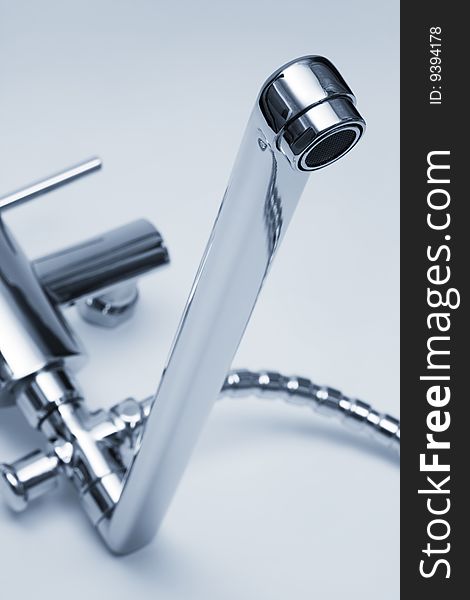 Modern metal faucet and shower close up