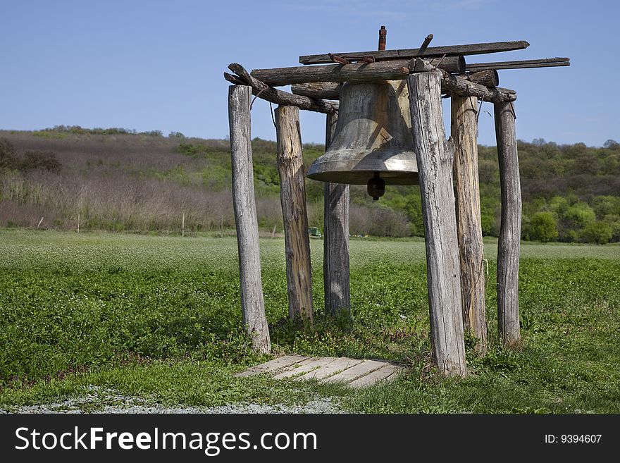 Big bell hanging in a wood structure pillar