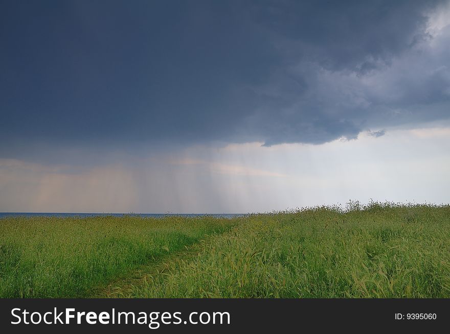 Afternoon thunderstorm with heavy showers on ear fields near the sea