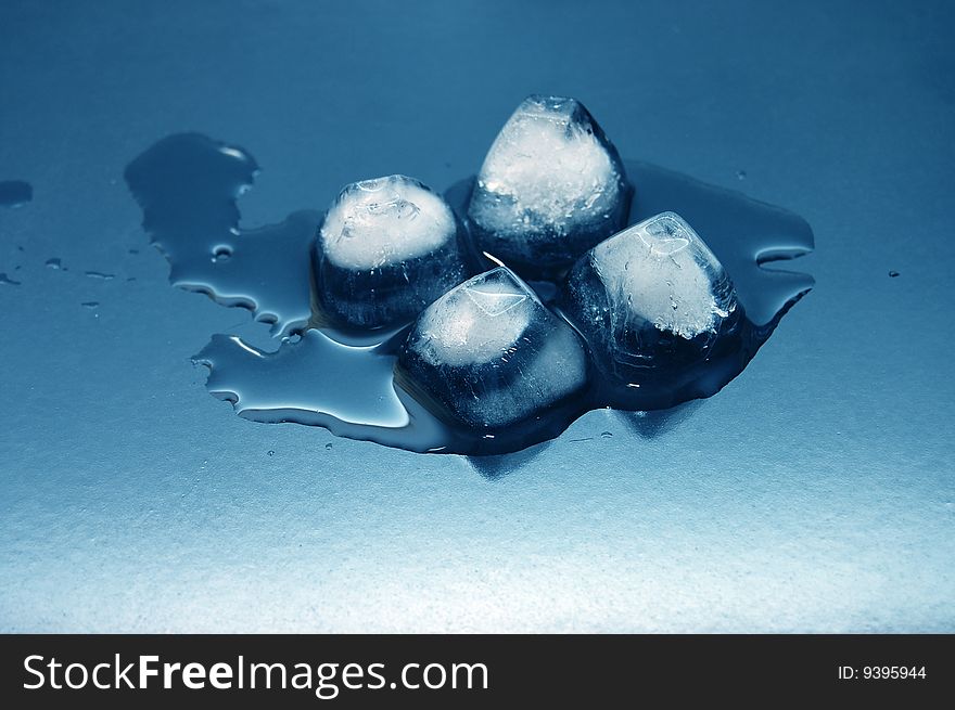 Colored ice cubes melted in water on reflection