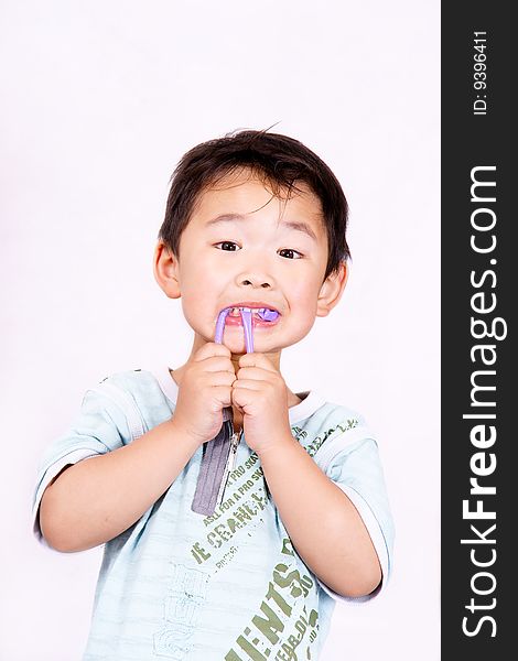 A picture of a little chinese boy playing with a purple straw. A picture of a little chinese boy playing with a purple straw