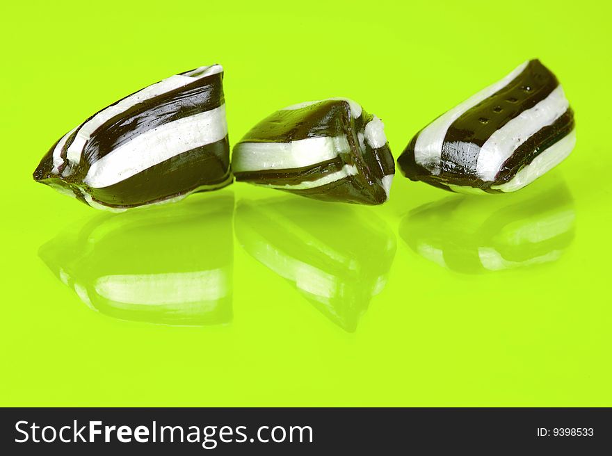 Humbug lollies isolated against a yellow background
