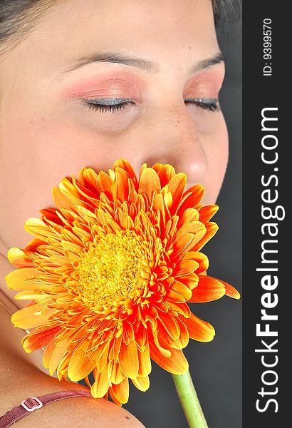 Shy girl with gerbera flower looking beautiful