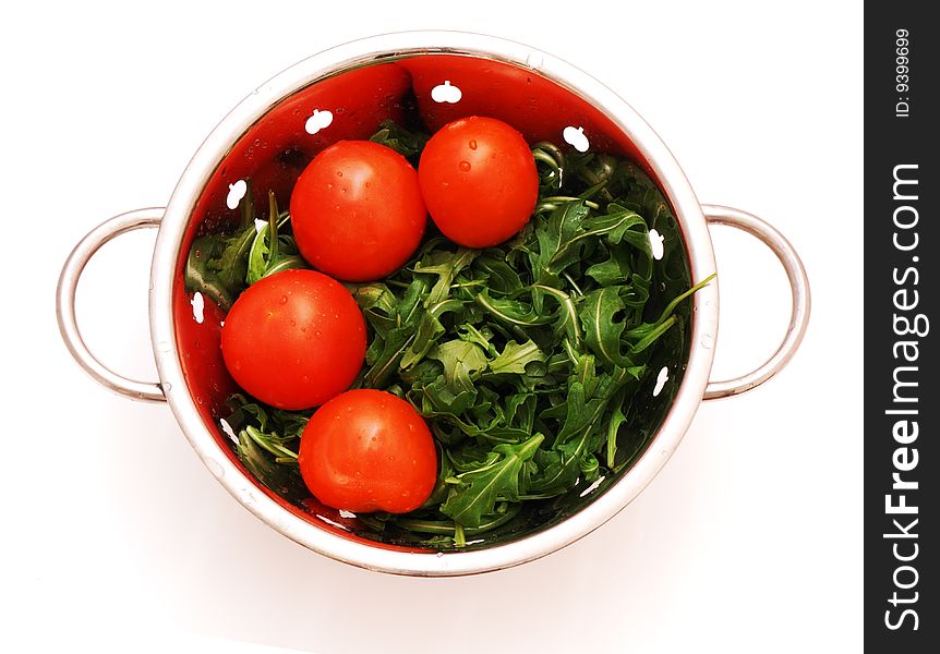 Arugula And Tomatoes In Stainless Steel Stainer