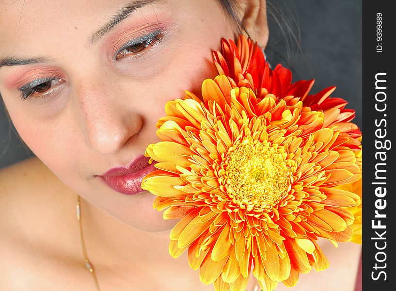 Girl with flower looking beautiful in studio.