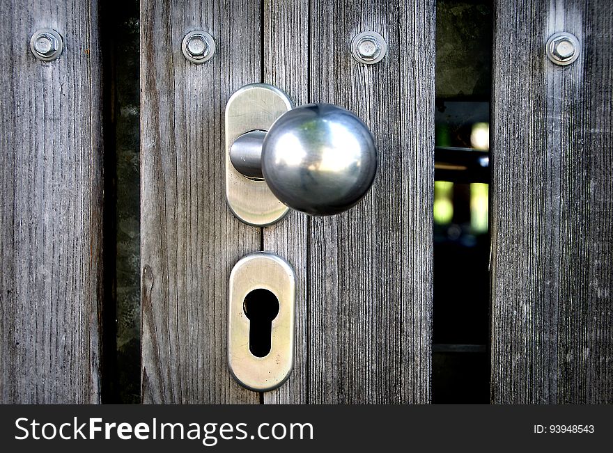 Closeup of a doorknob on a wooden door.