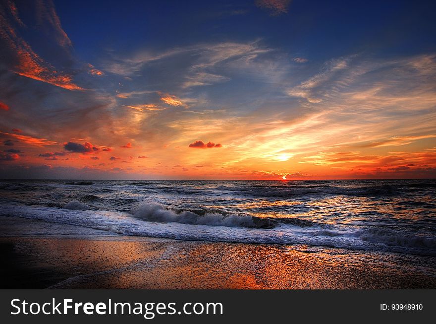 A beautiful beach sunset with waves crashing on the shore.