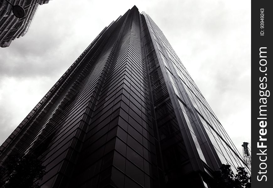 A low angle view of a skyscraper in black and white. A low angle view of a skyscraper in black and white.