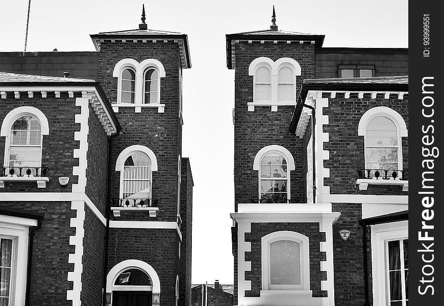 Exterior of brick houses with windows and spire in black and white. Exterior of brick houses with windows and spire in black and white.