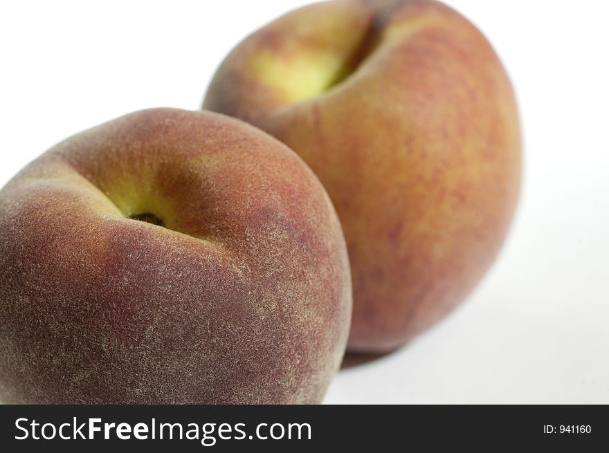 Two peaches in close-up against a white background