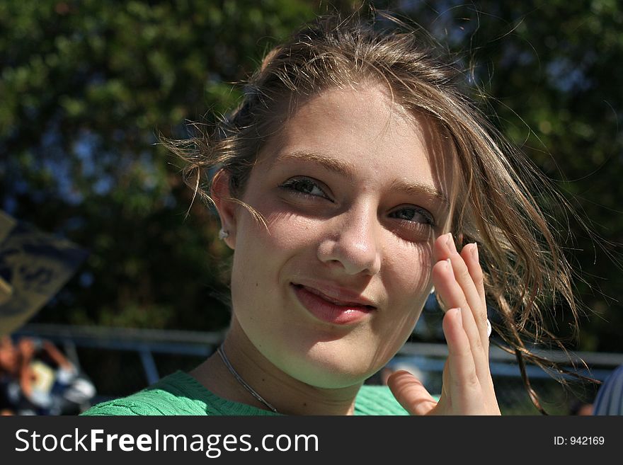 Teenage girl brushes hair off her face. Teenage girl brushes hair off her face